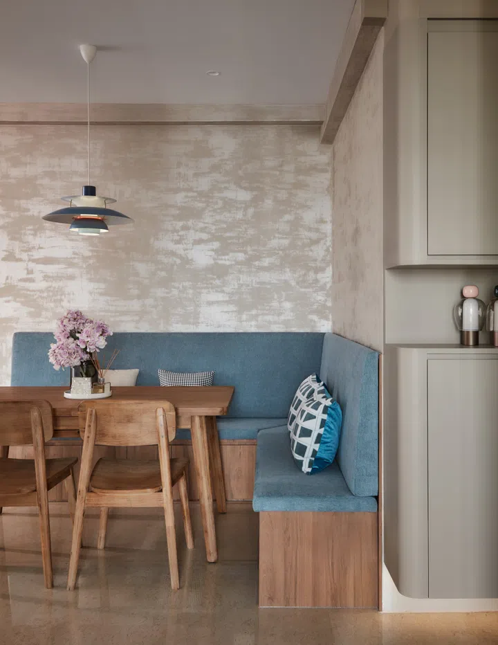 A custom-built L-shaped settee in dusty blue anchors the dining nook, maximising space and offering hidden storage beneath.