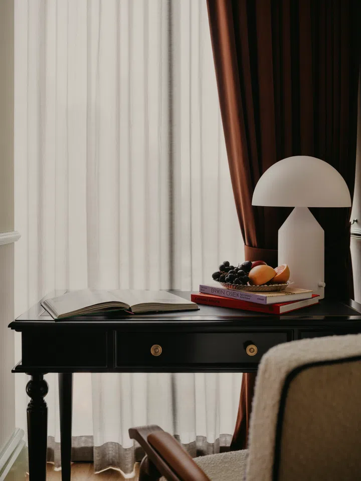 Rich marbles, wood, and drapery in the rooms of NoMad Hilton Singapore.