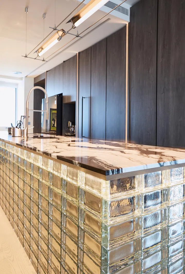 Kitchen countertop island is perched atop a glass brick base.
