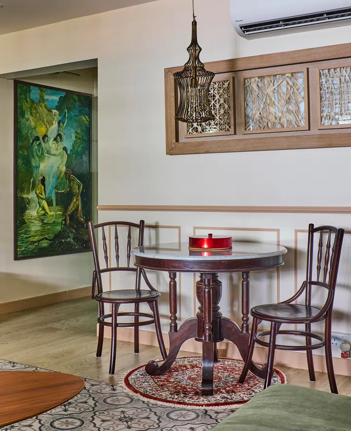 A modest dining setup with a round marble-top table and dark wood chairs, echoing classic kopitiam style in a 4-room HDB resale in Sunset Way.