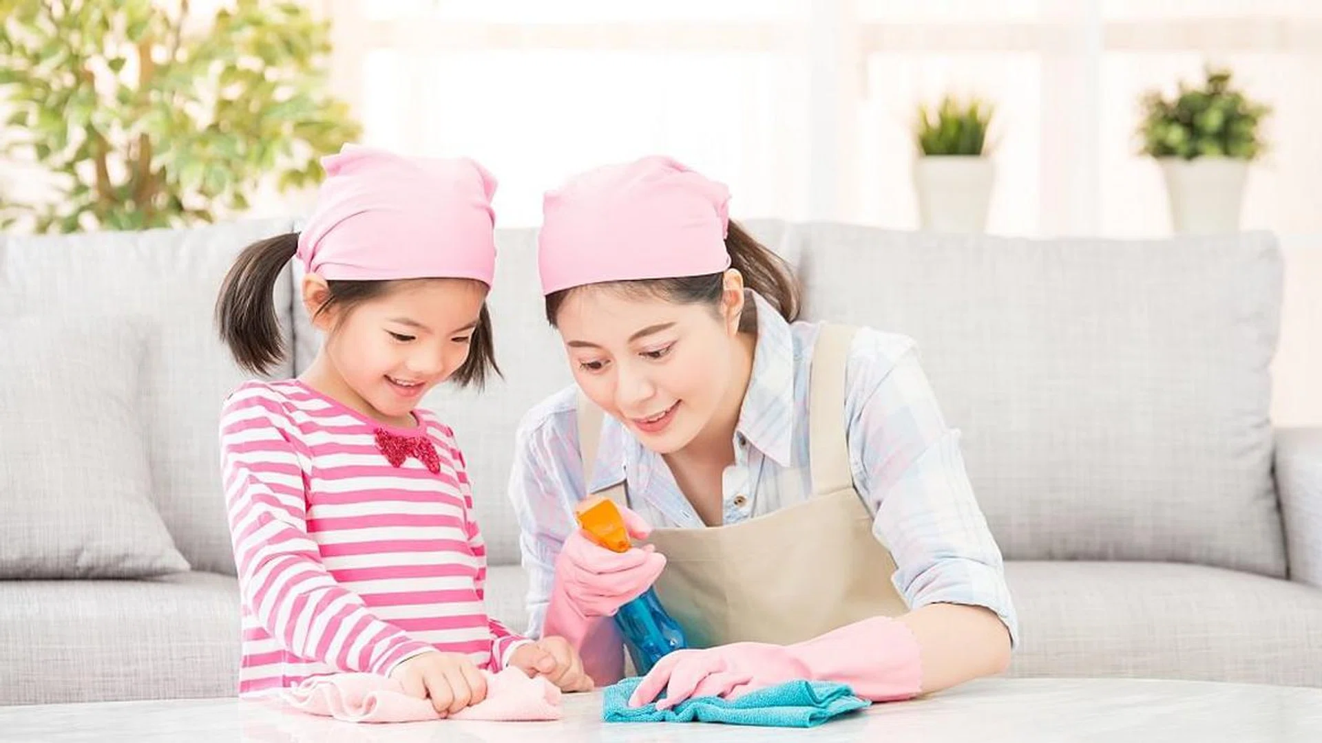 Happy family cleans the living room. Mother and daughter do the cleaning in the house. A young woman and a little child girl dusting. family housework and household concept.