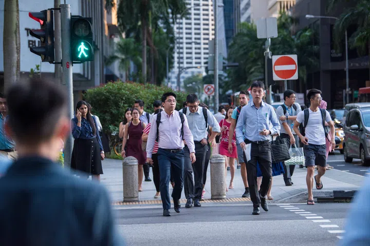 Singapore City, Singapore - September 08, 2019: At the end of the working day office workers walking on the streets of the Central Business District.