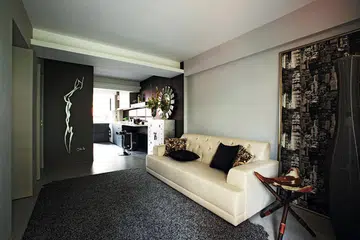 Guests in the living room may not guess that there are two bedrooms behind the panel of walls extending to the kitchen in interior designer John Susanto's 3-room resale HDB flat.