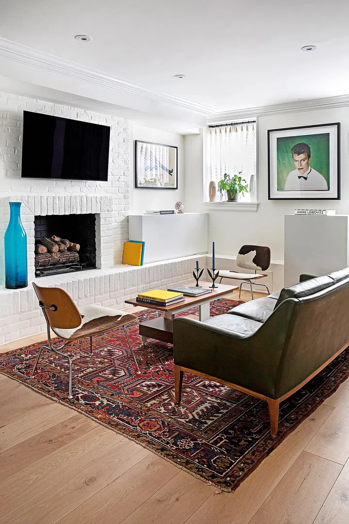 The brick accent wall provides texture to the white palette in the living room.