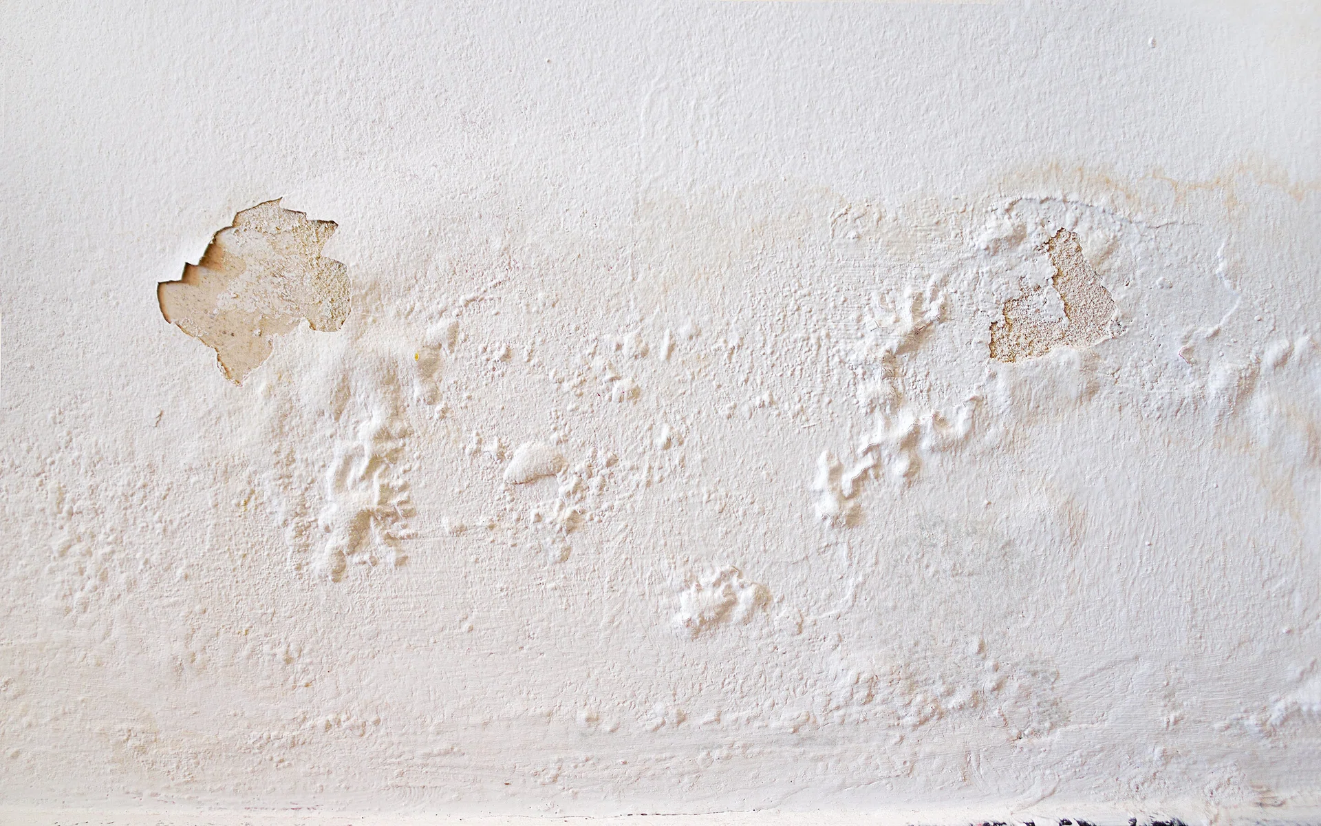 Rain water leaks on the wall causing damage and peeling paint.