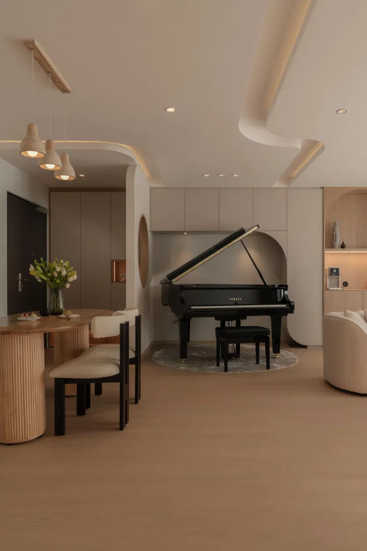 Curved ceiling lines and a sculpted alcove frame the baby grand piano.