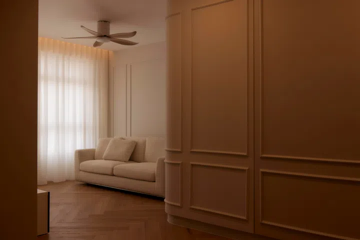 Wainscoting walls in the living room of a 4-room HDB BTO (1,004 sq ft) in Bishan, designed by RENOSTUD.IO.