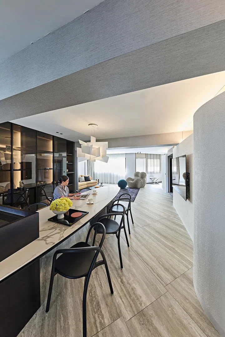 Homeowner Jessica poses for a picture at her custom-built curved dining table in her HDB executive apartment at Rivervale Plains.