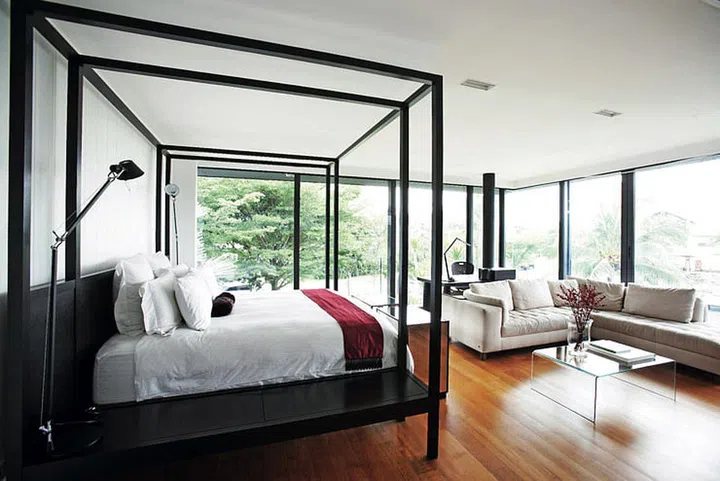 Desk lamps from Artemide flank the customised bed in the master bedroom of this 2-storey bungalow in Sentosa Cove. The design was inspired by a cosmetic tycoon’s luxurious beach home.