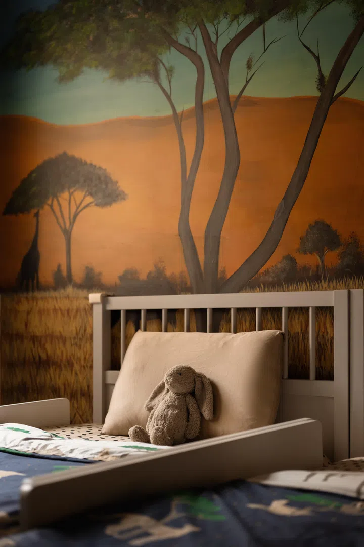 A favourite bunny sits beneath Zee’s hand-painted safari mural, watching over the room’s everyday adventures.
