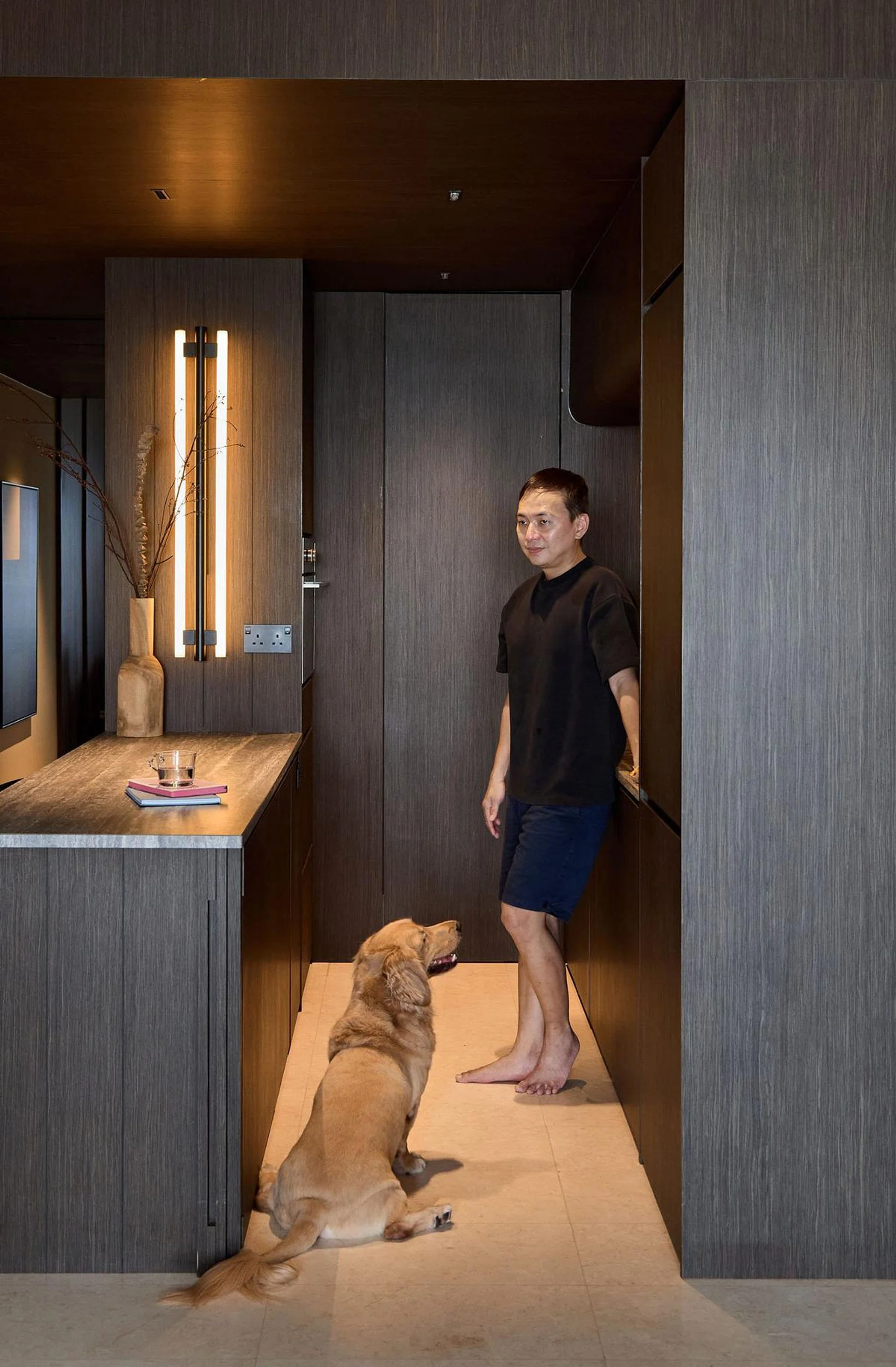 Kelvyn Lim posing for a photo with his golden retriever in his 840 sq ft 2-bedroom condominium at Hillview Rise.