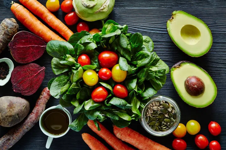 Fresh organic salad with avocado beetroot carrots and tomatoes.