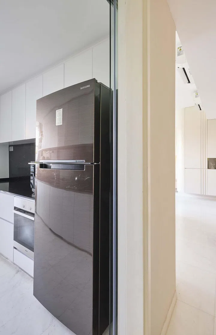 A black fridge in the kitchen of this 1,550 sqft 3-bedroom condominium apartment in Keppel Bay. Interior design by Weiken.