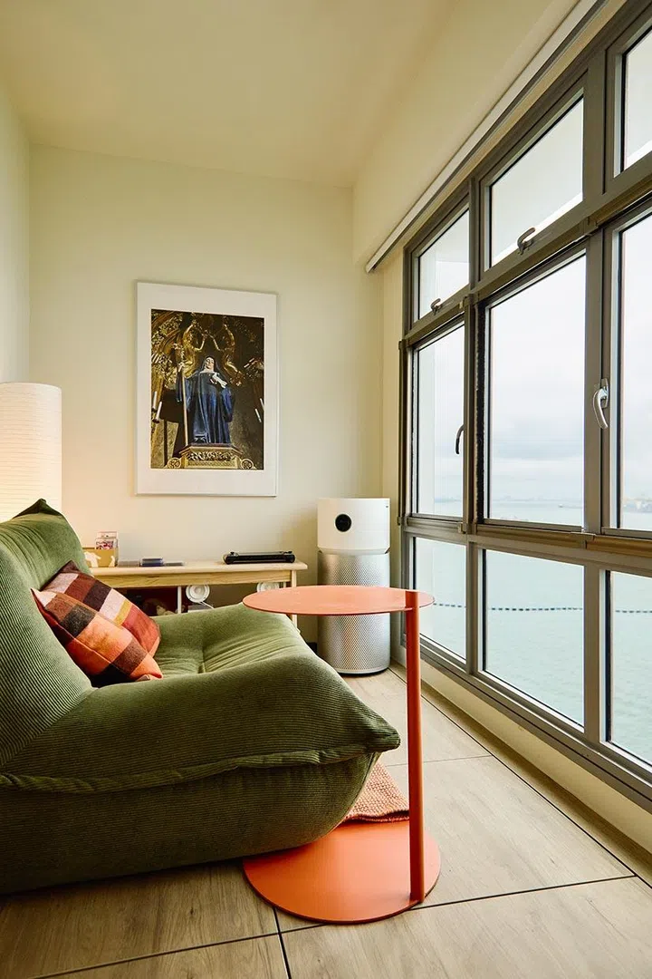 A deep green lounge chair brings softness and weight to the corner by the window—chosen for comfort first, and for how it makes the room feel.