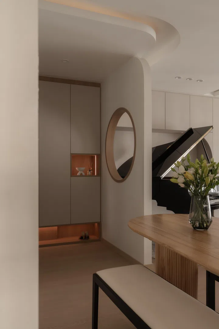 Curved ceiling lines flow seamlessly into full-height cabinetry, using form rather than partitions to define zones while maintaining openness.