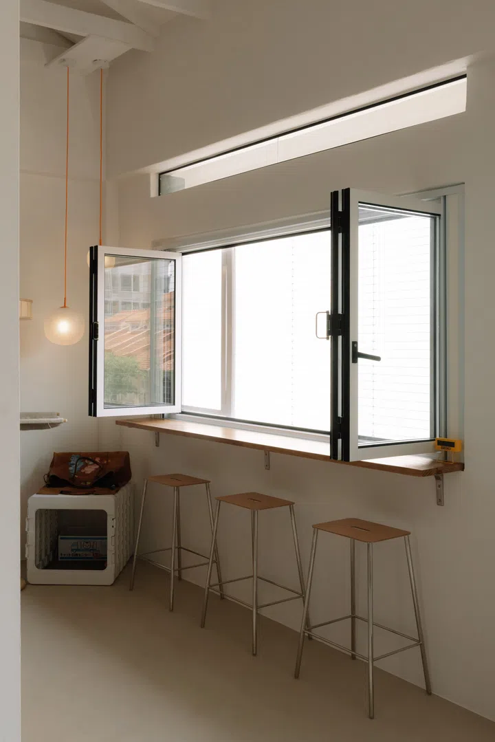 Rather than settling for standard windows, the couple worked with their designer to commission an inward-opening version, allowing the apartment to be safely cat-proofed without compromising ventilation or natural light.