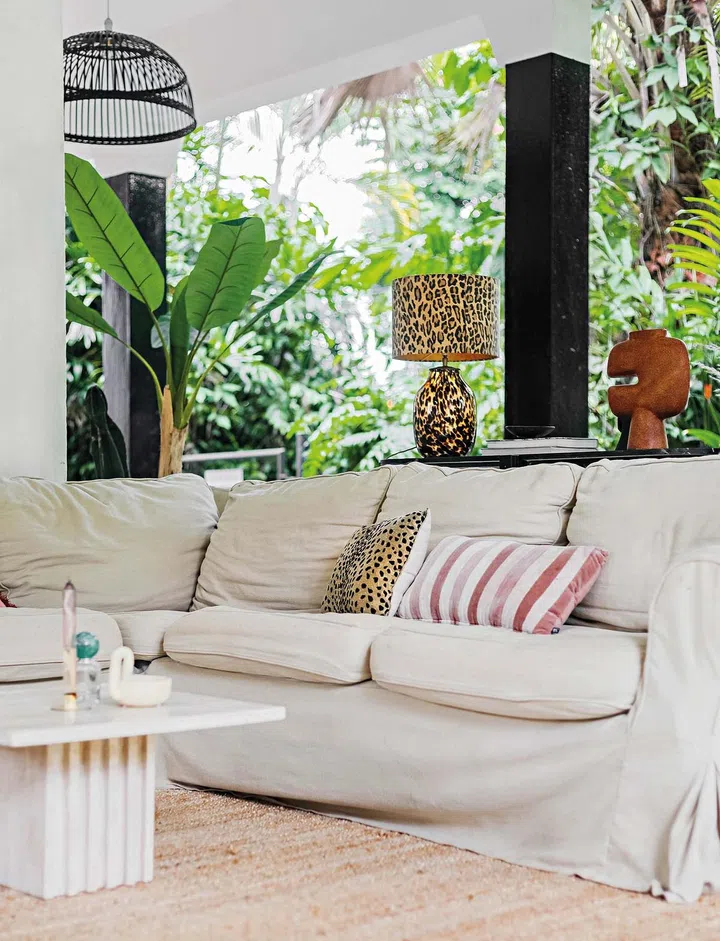 A beige couch outdoors with cushions and various decor