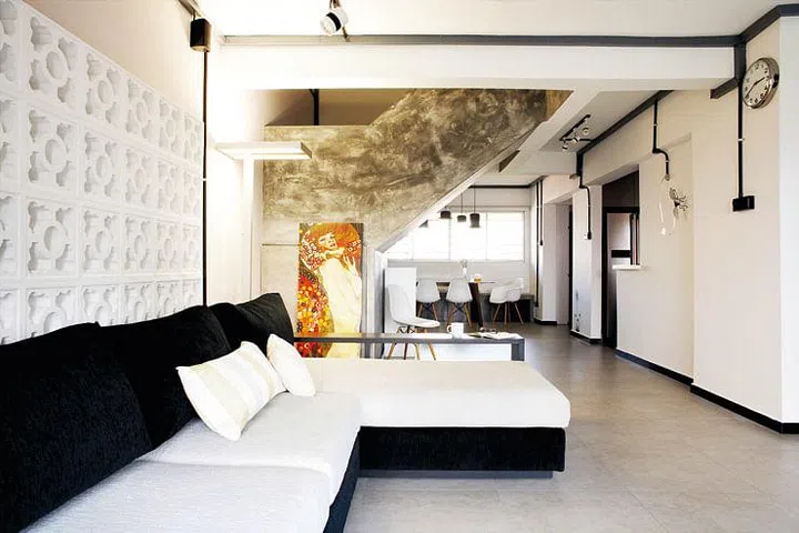 The inviting living room showcases a multifunctional sofa from Cellini, thoughtfully selected for its integrated side shelf that provides convenient storage for the children’s books.