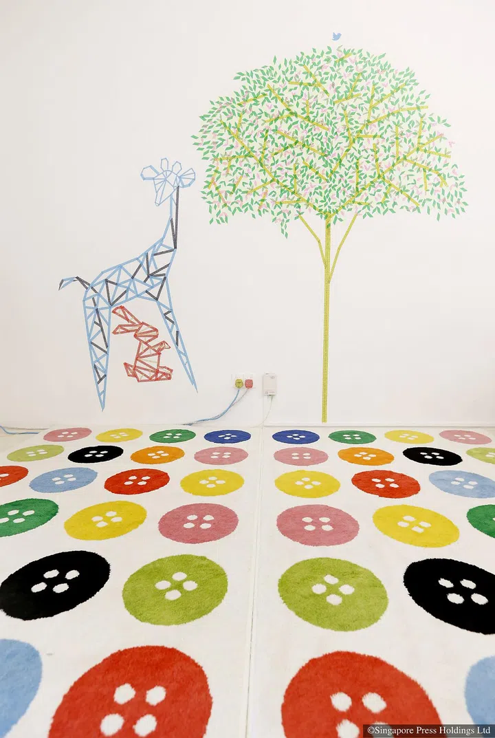 A mural of a giraffe in a forest pasted on the wall using washi tape, a decorative adhesive tape used in handicrafts projects. The spontaneous quality of the colourful washi tape sets a playful tone for the rest of the home of Ms Shi Xiao Wei and her husband Dickson Seow. 