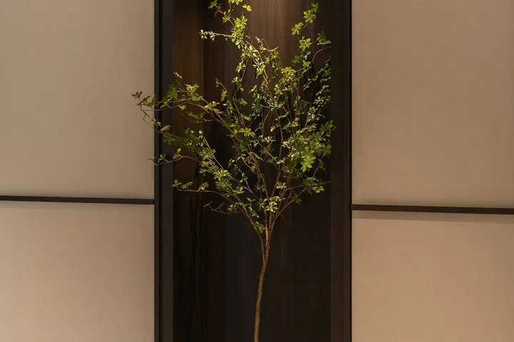 A recessed planting niche was introduced to break up the long run of linen-look laminated cabinetry in the foyer.