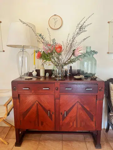 A Mid-Century Modern sideboard in my home, where dinner and servingware are stored away in an open-plan dining and living area