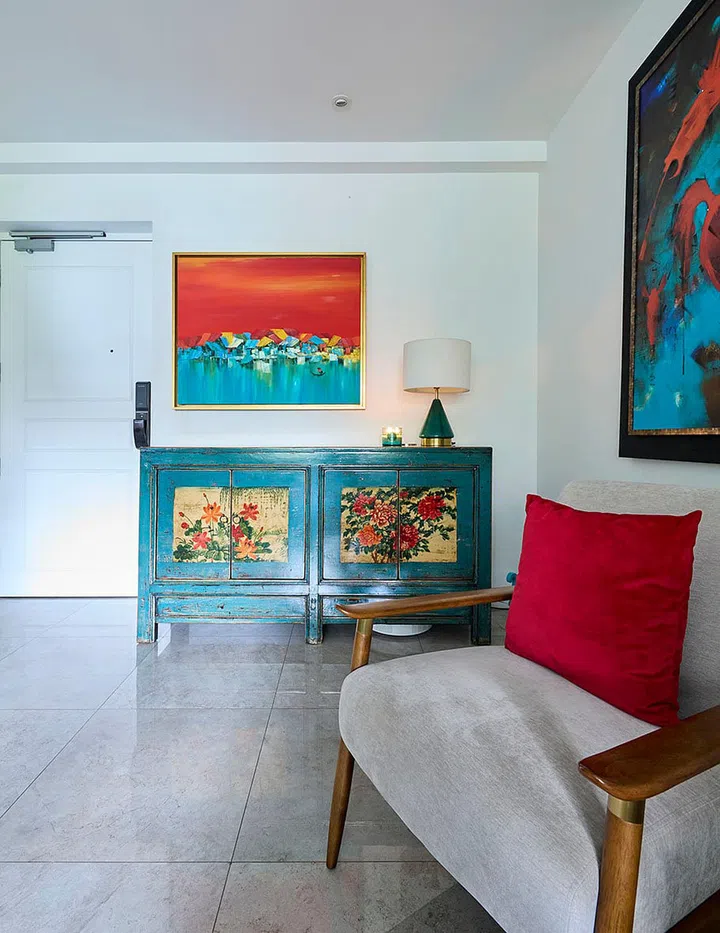 Homeowner Gayatri’s love for the arts is immediately evident in the home’s entryway that segues into the living room: a painting depicting a serene jetty at sunset is perched above a teal-colored vintage Chinese cabinet by the door.
