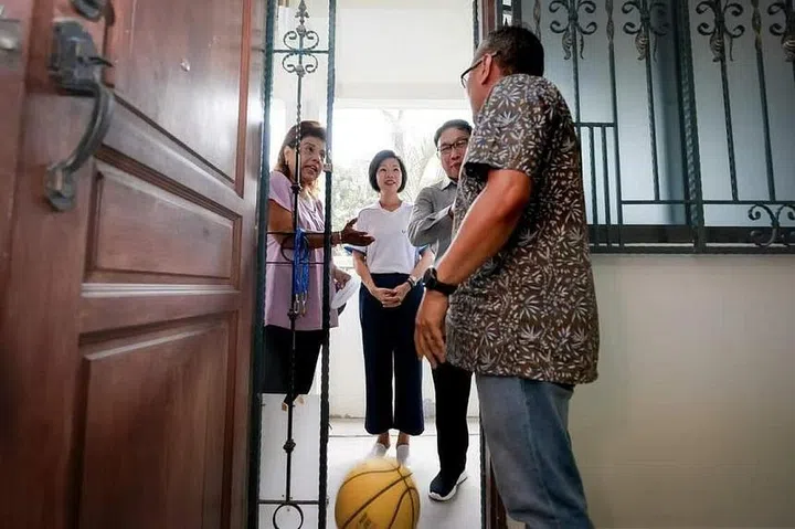 Senior Minister of State for National Development Sim Ann (in white) role-playing as a resident to negotiate with a neighbour who is bouncing a basketball loudly in his flat. ST PHOTO: GAVIN FOO