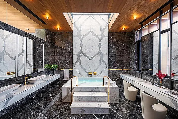 A grand marble bath flanked by marble sinks and pillars