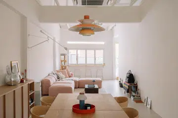 The home's open-plan living and dining spaces are framed by exposed roof trusses and bespoke oak cabinetry, complemented by carefully curated furniture and lighting from some of the couple's favourite Nordic brands.