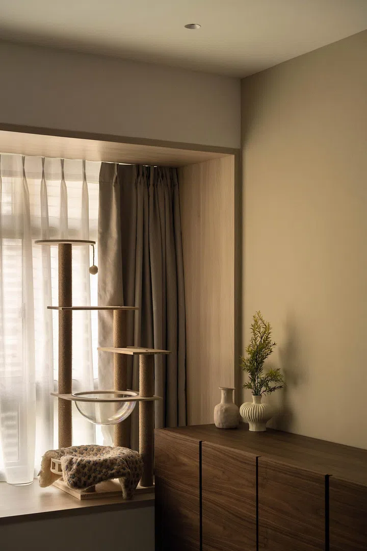  A tall cat tower by the bay window turns the study into a shared space for focus and play.
