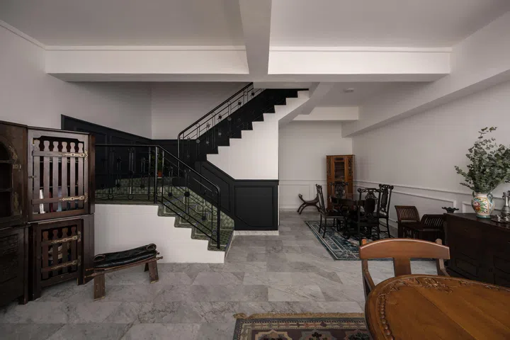 The open-plan living area is grounded by polished marble floors and solid dark wood antiques.