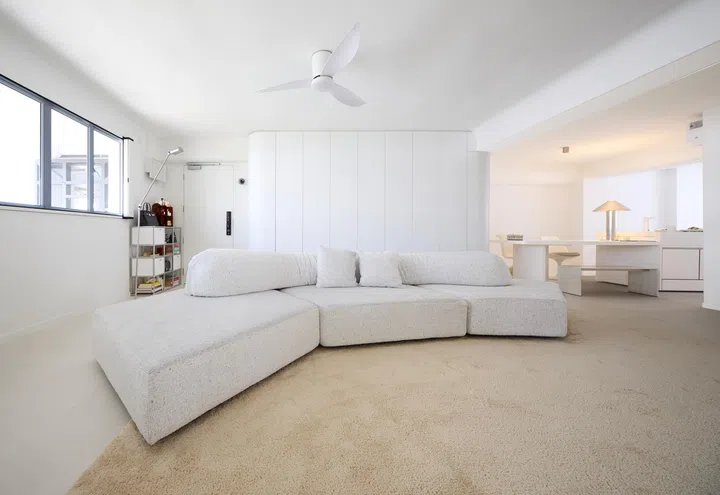 Light white tones bounce off one another, balancing the living room space. 
