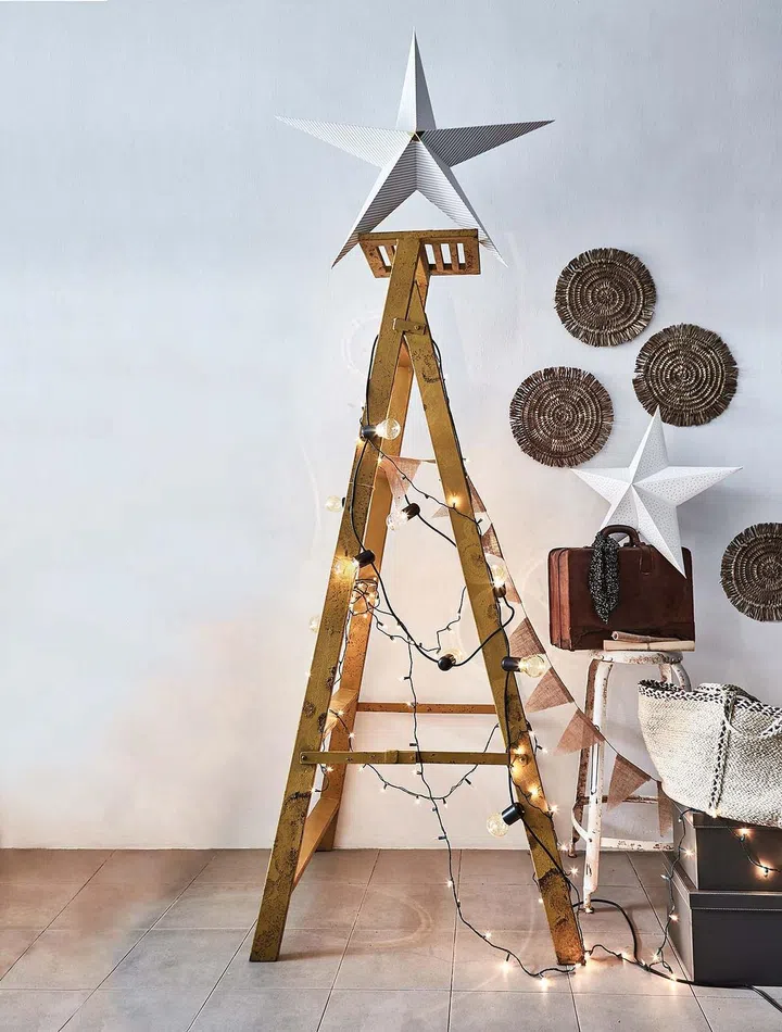 A makeshift ladder Christmas tree with fairy lights hung around.