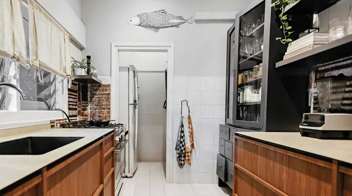 The existing kitchen counter was extended to make room for a coffee station. To avoid hacking the wall tiles in the rental unit, Barbara wallpapered the backsplash with special heat-resistant and waterproof wallpaper.