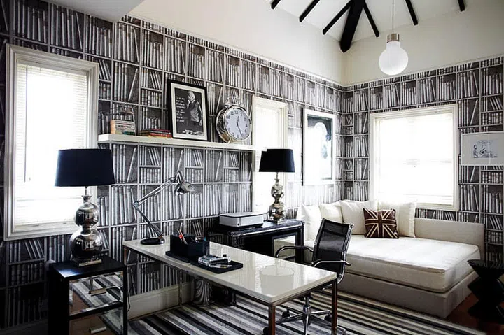 From the striped carpet to the bookshelf-print Fornasetti wallpaper by Cole & Son, the study/guest room is a refreshing break
from the vivid colours in the rest of the home.