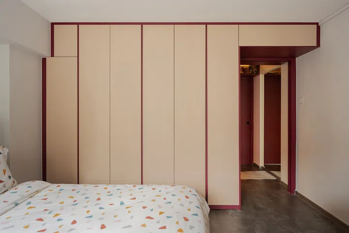 The master bedroom hides a vanity within its cream and burgundy full-height wardrobes.