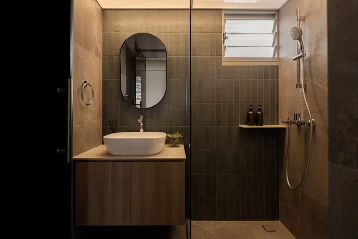The guest bathroom is done up in a combination of sage green kit-kat tile with a dark grey stone texture. 