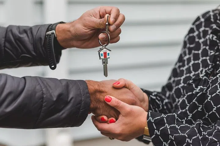Two hands exchanging a set of house keys