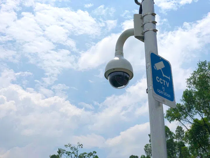 Surveillance camera (CCTV) in operation with warning sign