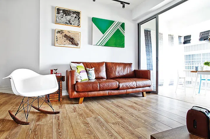 The interior designer, JQ Ong from The Association, has a knack for combining styles, matching a leather sofa with an Eames rocker and his own painting with two small pieces he found at a thrift store now framed on the walls above the tan leather sofa.