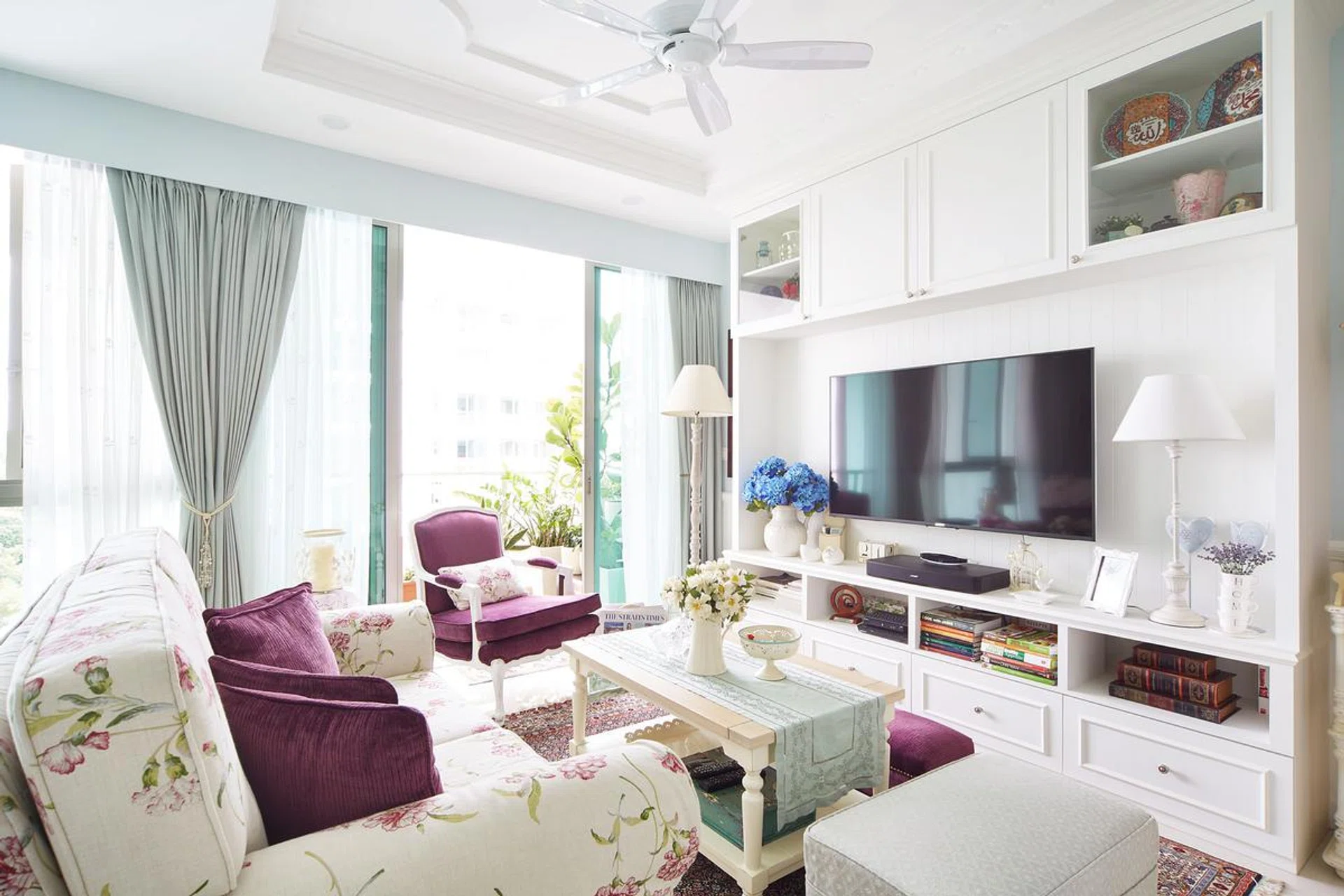 Keeping the space mainly white, the designer added trimmings on the cabinetry in the living room to bring out the character of the theme. A soft powder blue on some walls soften the starkness of white.
