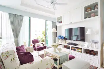Keeping the space mainly white, the designer added trimmings on the cabinetry in the living room to bring out the character of the theme. A soft powder blue on some walls soften the starkness of white.