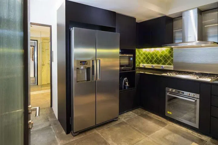 The retro chic kitchen has vintage-glazed ceramic tiles in this (originally) 3-bedroom condominium facing East Coast Park.