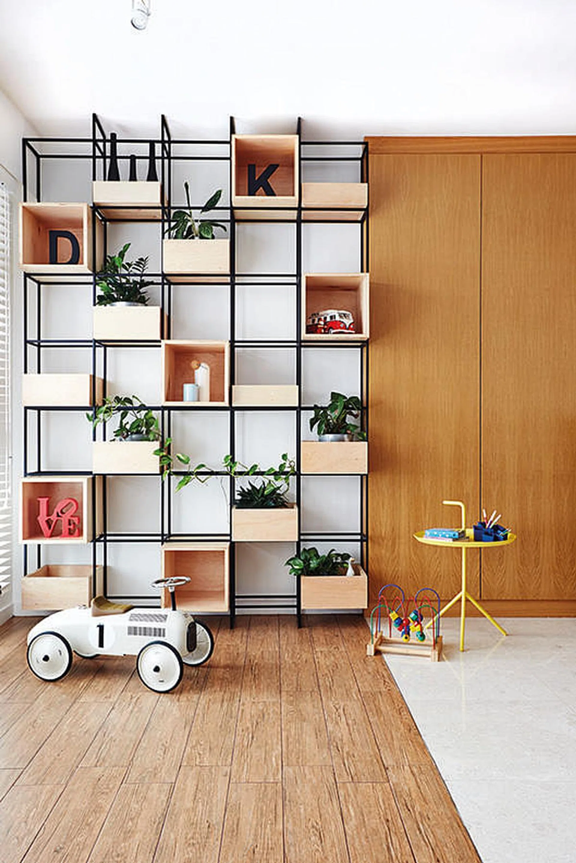 Timber-grain porcelain tiles were used for the flooring to delineate the play area from the main living hall, and lend a touch of rusticity to the interiors. Yellow Hay table from Foundry.