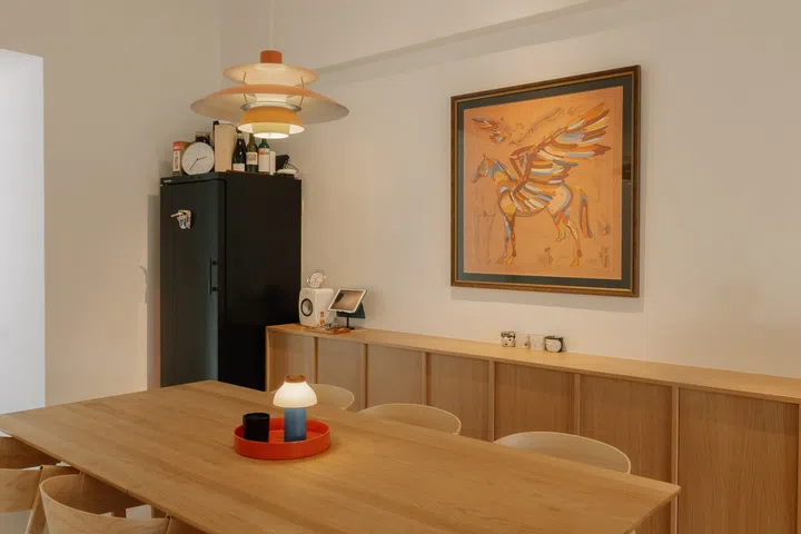 A Louis Poulsen PH 5 pendant casts a warm glow over the dining table, reinforcing the space’s role as the social heart of the home.