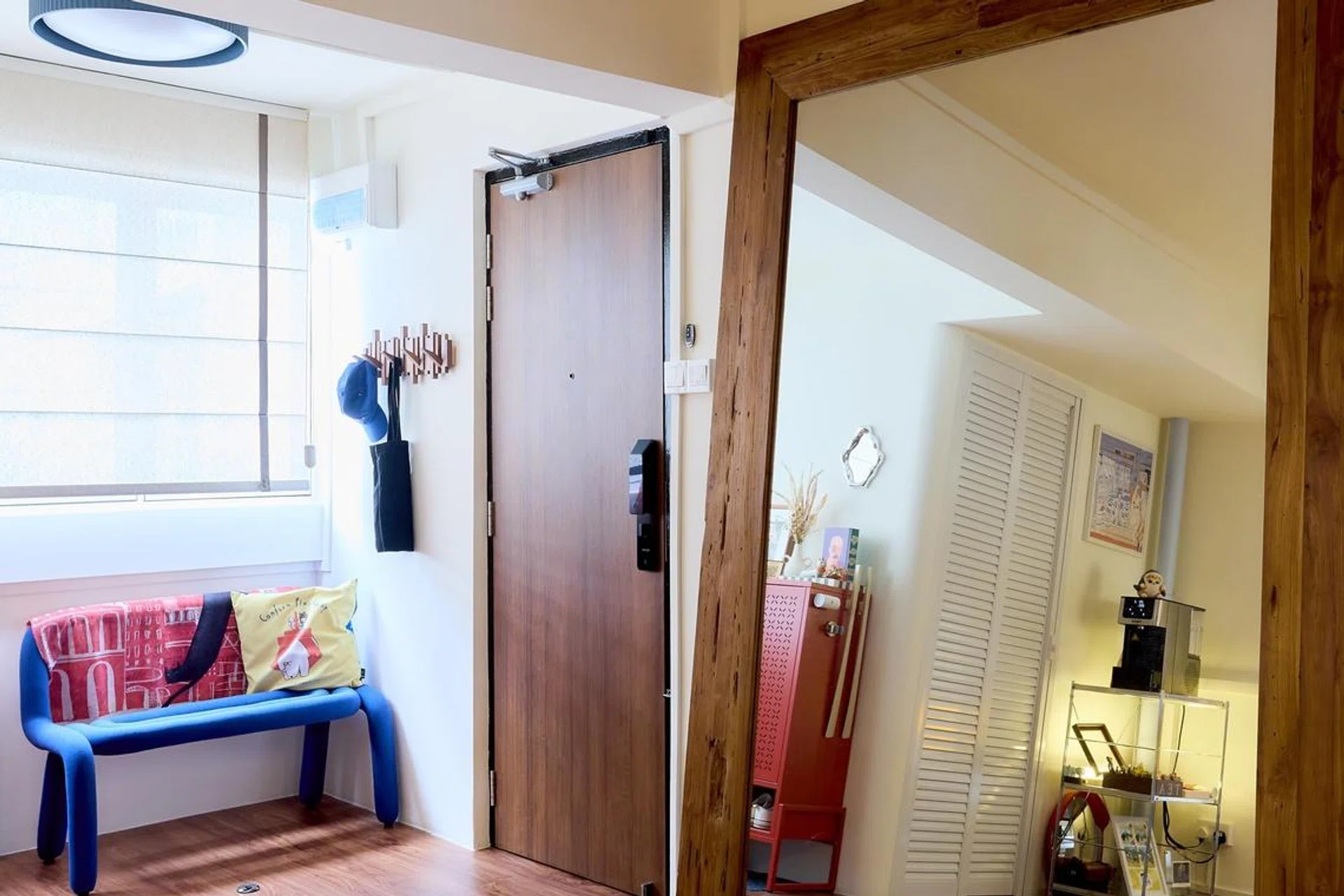 Entrance foyer chair and oversized mirror by the main door in a 5-room HDB flat in Yishun, designed by Homely Matters Pte Ltd.