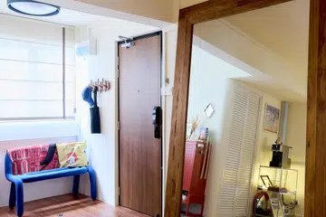 Entrance foyer chair and oversized mirror by the main door in a 5-room HDB flat in Yishun, designed by Homely Matters Pte Ltd.
