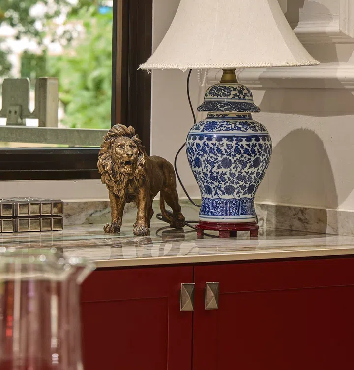 Everyday objects, such as a lion figurine placed on the countertop, contribute to the home’s layered and lived-in character.
