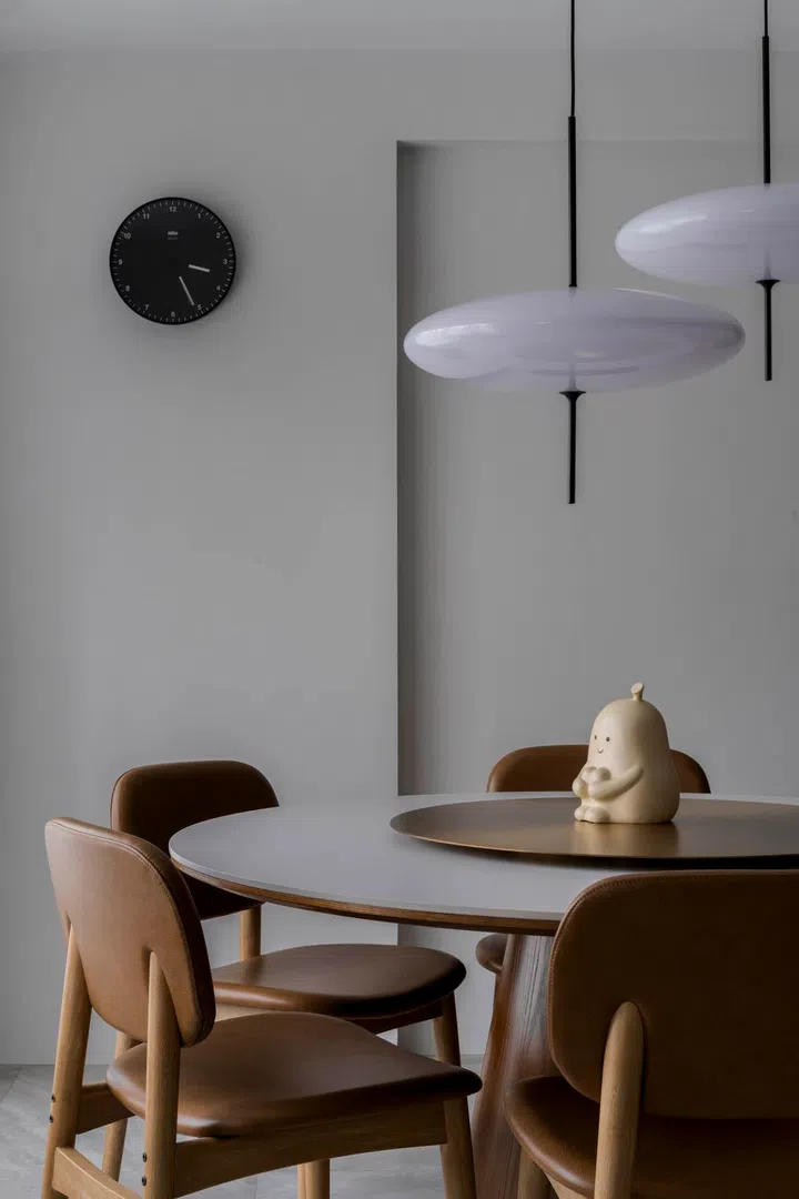 A pared-back dining table sits under a sculptural pendant, keeping the look minimalist yet distinctive.