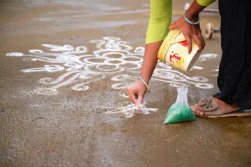 Kolam Rangoli, colorful sand painting drawing, women and girls at evening of Holi festival in India, Indian religion and culture, Hinduism celebration.